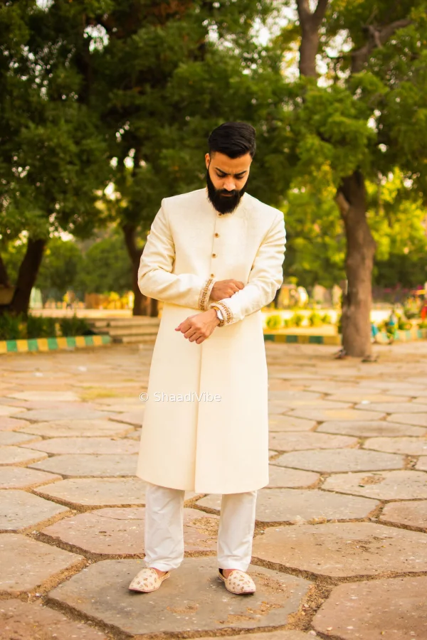 Sophisticated groom pose featuring the groom adjusting his cufflinks sleeves before the wedding ceremony.