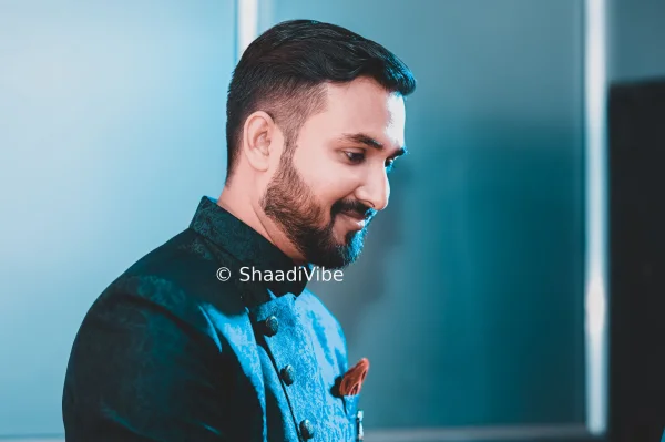 Side-profile groom portrait highlighting the groom's sherwani, safa and traditional wedding accessories.