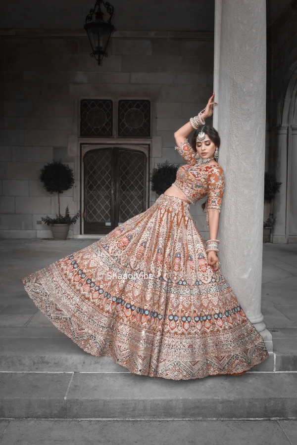 Contemporary beige bridal lehenga with tonal embroidery for a sophisticated neutral-toned Indian bridal look with touch of rustic orange and teal.