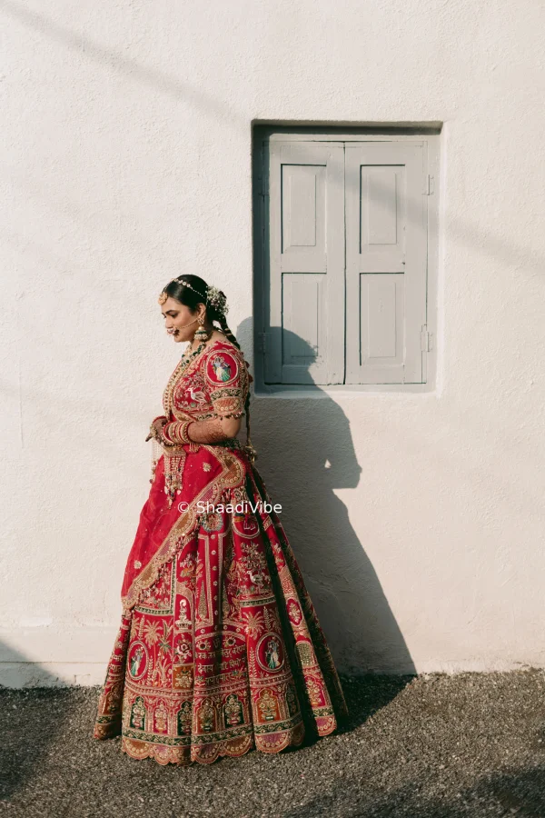 Red bridal lehenga featuring detailed embellishment and a luxurious silhouette for a statement Indian wedding look.