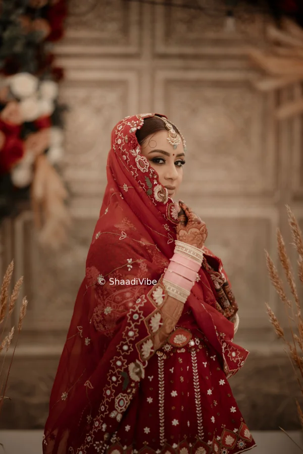 Regal bridal portrait featuring an Indian bride in a richly detailed lehenga with layered jewellery and traditional styling.