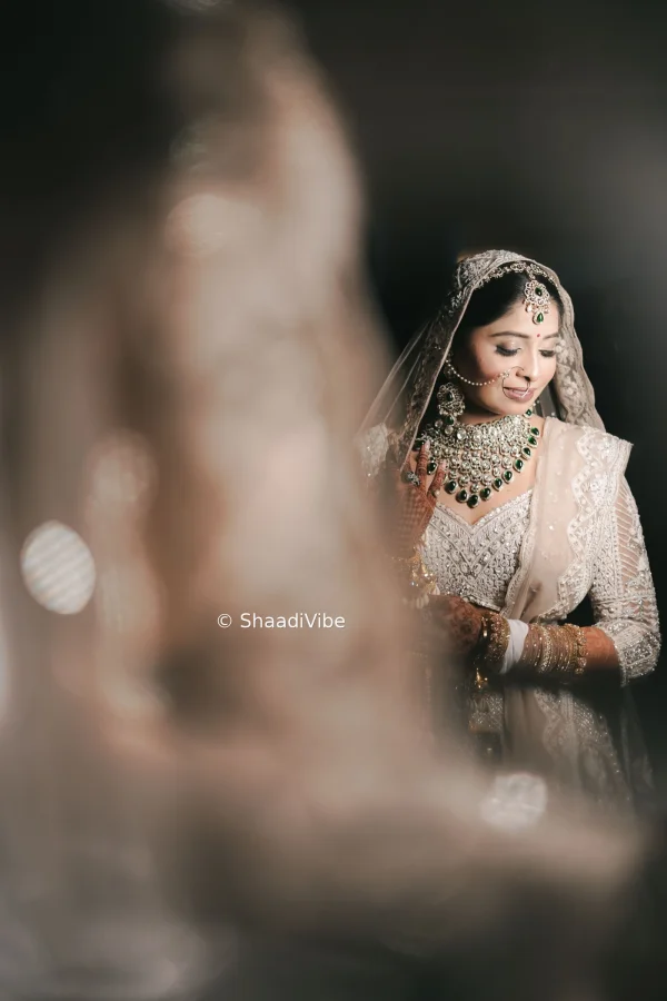Timeless bridal portrait showcasing an Indian bride in a richly embroidered lehenga with traditional wedding jewellery.