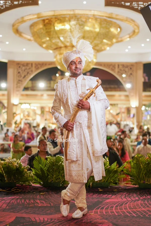 Royal cream sherwani featuring detailed gold motifs and traditional styling for a grand Indian wedding ceremony.