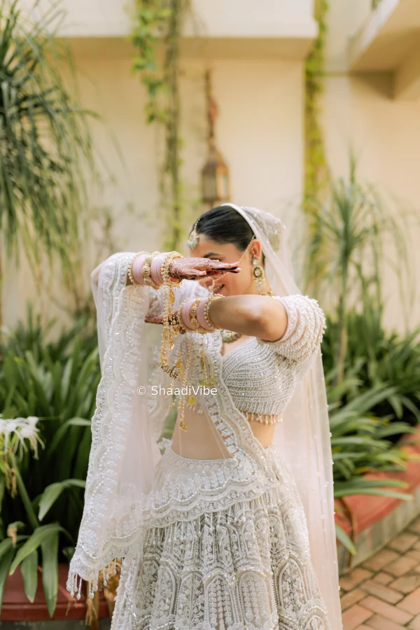 Bride is looking very adoring while hiding her face with her hands.