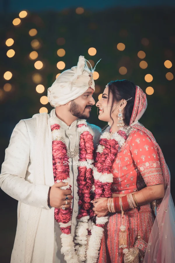 Traditional Indian wedding couple posing together in front of the mandap for a classic bride and groom photograph.