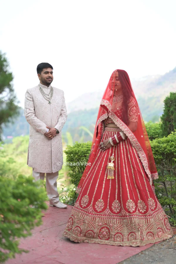 Romantic Indian wedding couple pose featuring the bride and groom standing together in their wedding outfits for a timeless photograph.