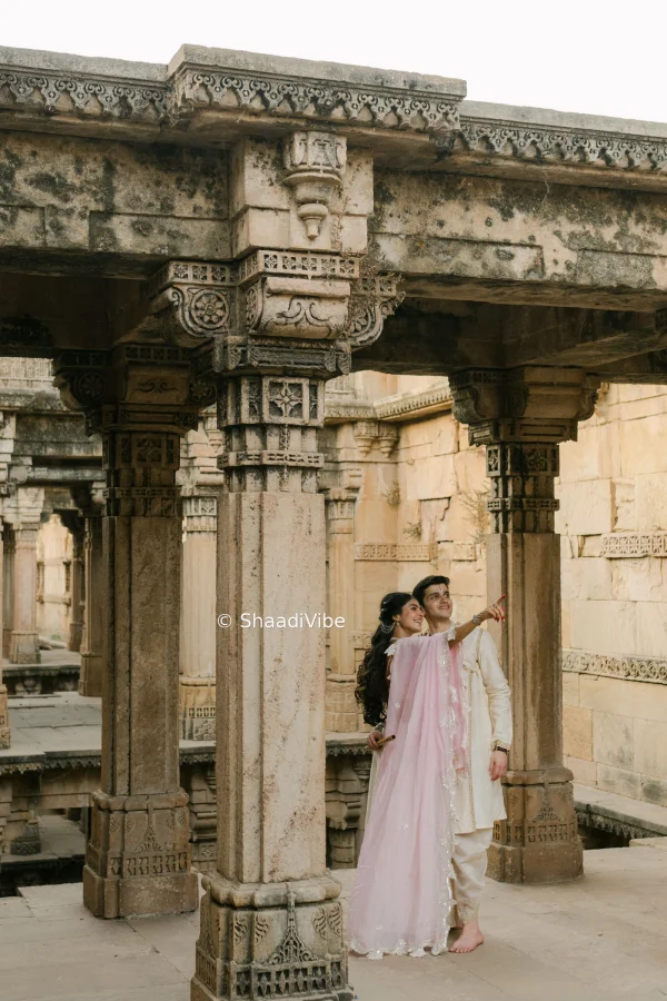 Cinematic pre-wedding couple photograph featuring the bride and groom sharing a romantic moment against a dramatic landscape of adalaj ni vaav