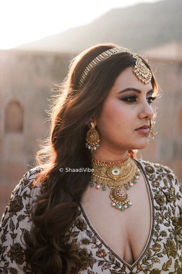 Soft bridal curls styled with a delicate maang tikka and  for an elegant wedding day look.