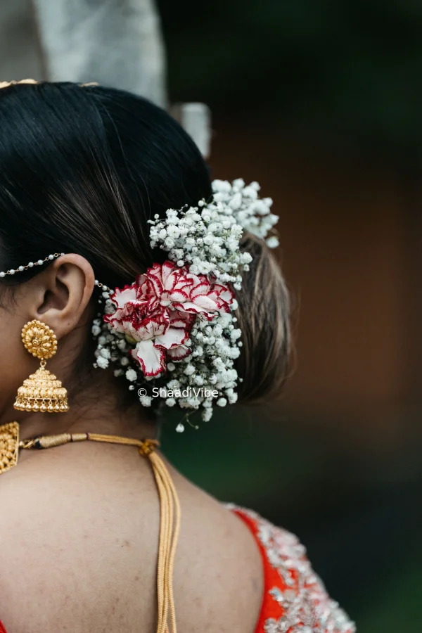 Elegant Indian bridal bun decorated with fresh flowers, creating a classic and timeless wedding hairstyle.