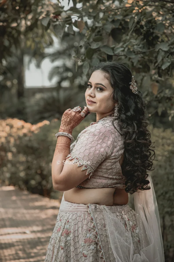 Elegant open hairstyle with soft curls and statement bridal hair accessories for a glamorous Indian wedding look.