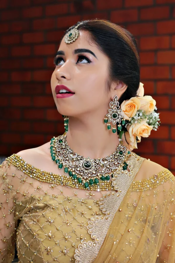 Emerald and gold bridal jewellery paired with a traditional necklace and earrings for a rich and regal Indian wedding look.