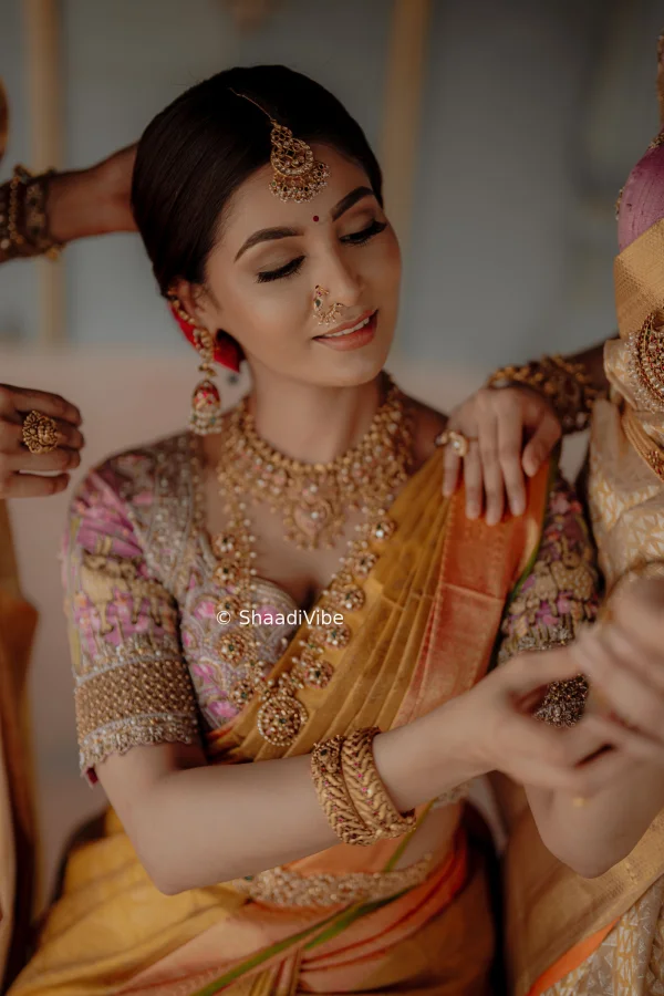 South Inidian bride looking elegant while wearing a musturd saree paired with temple jewellery