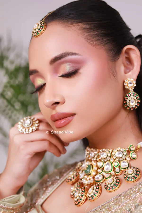 Elegant Indian bridal portrait featuring a red lehenga, traditional kundan jewellery and soft glam makeup.