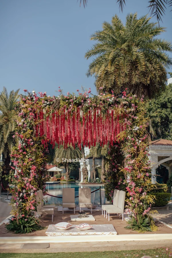 Photo of Pretty red and peach hanging florals mandap for an outdoor wedding